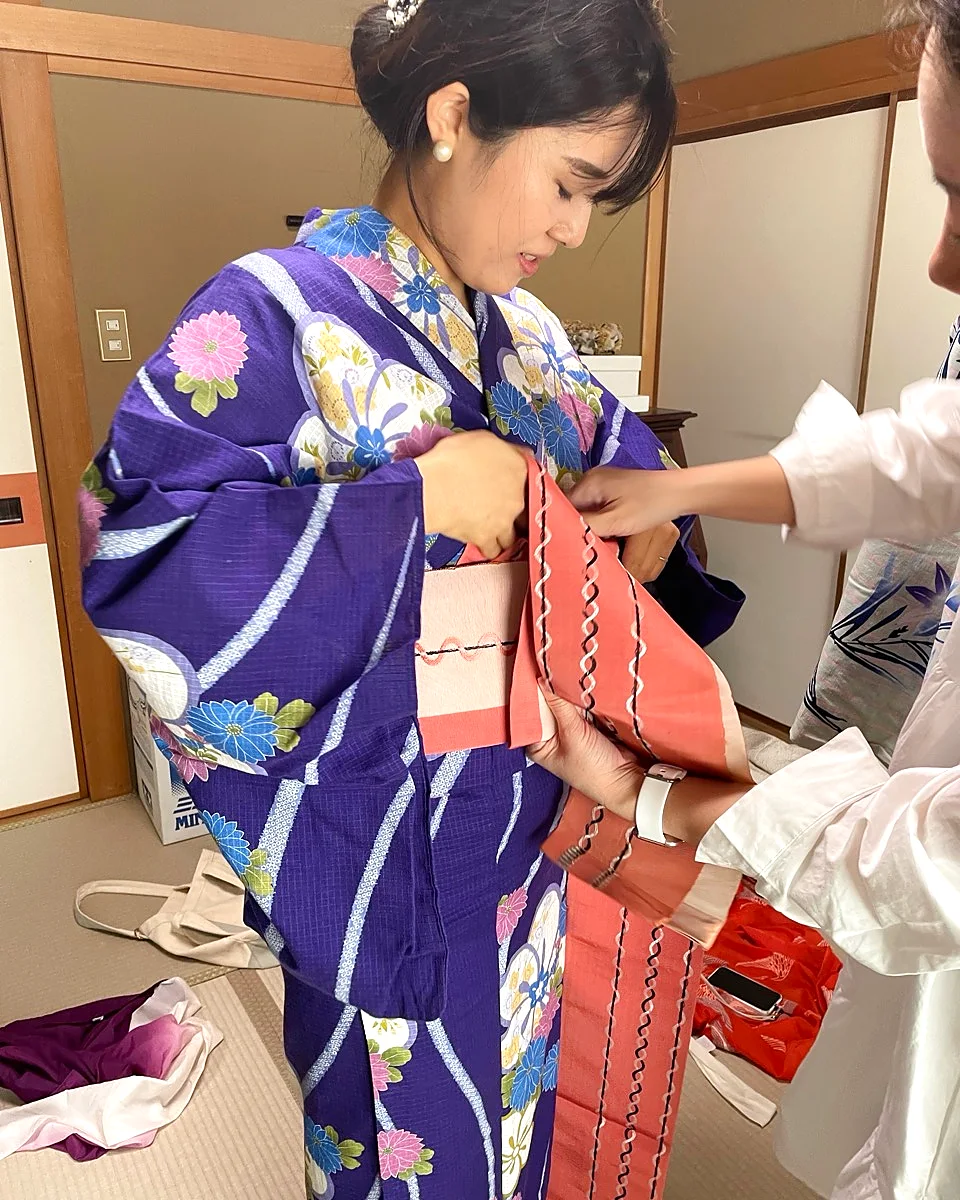Kimono staff adjusting a guest's obi sash
